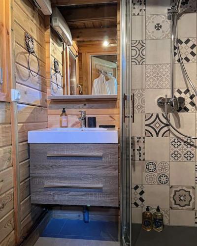 une salle de bain avec un lavabo et une douche dans l'établissement Chalet Authentique - Insolite - Sauna & Télécabine - Ménage, serviettes, lit fait inclus, à Rochesson