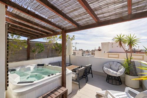 a patio with a hot tub on a roof at Luxury Penthouse apartment Nerja in Nerja