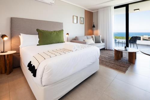a bedroom with a large white bed and a living room at The Tyne Luxury Apartments in Durban