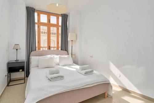 a bedroom with a bed with towels on it at Luxury Penthouse apartment Nerja in Nerja