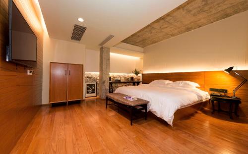 a bedroom with a large bed and a flat screen tv at Zhuhai Bei Shan Ju Art Hotel in Zhuhai