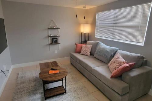 a living room with a couch and a table at Busch Gardens Bliss Retreat 1 Bedroom in Tampa