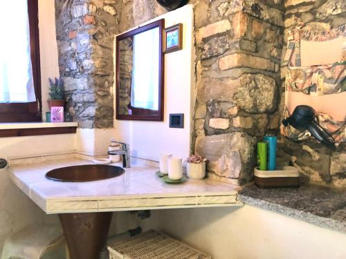 bagno con lavandino e parete in pietra di Sleep'n and go Country House a Menaggio