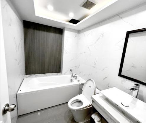 a white bathroom with a toilet and a sink at Rose Hotel - 13 Hẻm 12 Cù Lao, Q. Phú Nhuận - by Bayhostel in Ho Chi Minh City