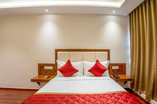 a bedroom with a large bed with red pillows at FabHotel Phoenix Horamavu in Bangalore
