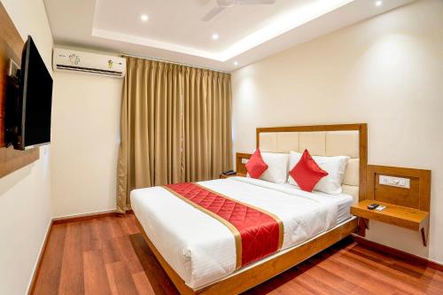 a hotel room with a bed and a television at FabHotel Phoenix Horamavu in Bangalore