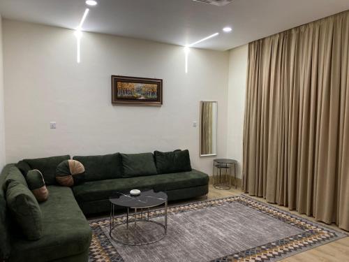 a living room with a green couch and a table at Sargali Duhok Hotel in Duhok