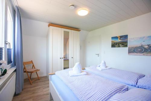 a bedroom with two beds with towels on them at Ferienhaus Daheim in Borkum