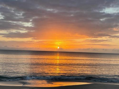 a sunset over the ocean with the sun in the sky at Ocean Dream Villa in Ushongo Mabaoni