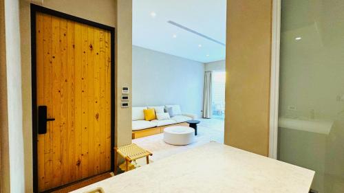ein Zimmer mit einer Tür und einem Wohnzimmer mit einem Sofa in der Unterkunft 拾嶼SheWill in Altstadt von Hengchun