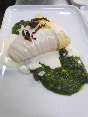 a dessert on a white plate with green sauce at Tenuta Oliva in Fisciano