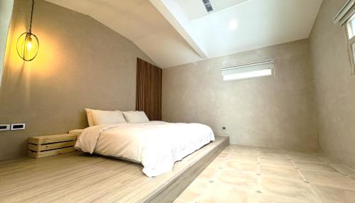 a bedroom with a white bed and a window at 拾嶼SheWill in Hengchun