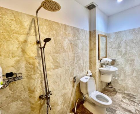 a bathroom with a shower and a toilet and a sink at Luxury Hotel - 50/3 Trường Sơn, Q. Tân Bình - by Bayhostel in Ho Chi Minh City
