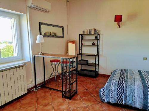 a room with a desk and a bed and a table at Au cœur du Félibrige in Châteauneuf-de-Gadagne