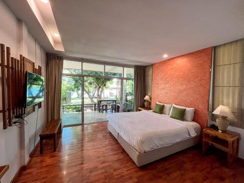 a bedroom with a large bed and a large window at ี เรือนปณาลี รีสอร์ท in Ban Khlong Sai Yok