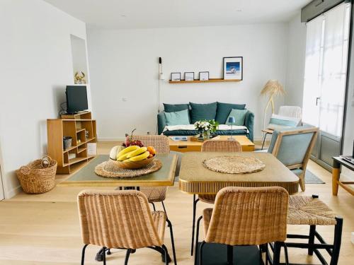 Una sala de estar con mesas y sillas y un sofá. en Villa Mary-Alex La Baule, en La Baule