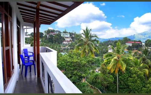 a balcony with blue chairs and a view of a city at SaRu Holiday Apartment - Upto 6 Guests in Kandy
