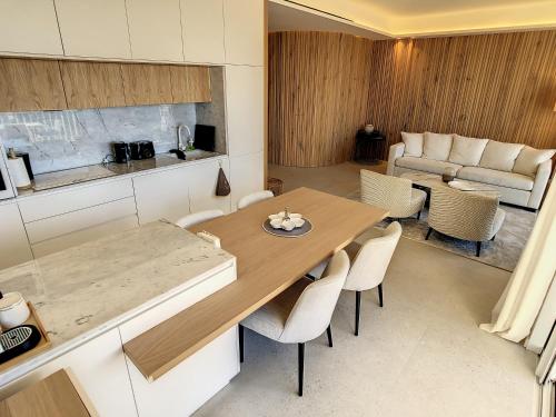 Il dispose d'une cuisine et d'un salon avec une table et des chaises en bois. dans l'établissement Luxury Amazing 3 bedrooms, 3 bathrooms on the Croisette 408, à Cannes