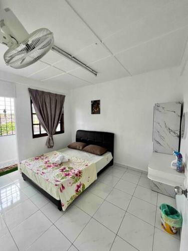 a bedroom with a bed in a white room at Sarah homestay Muslim Permatang Pauh in Permatang Pauh