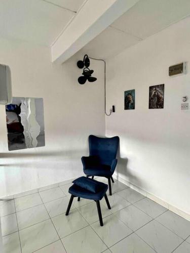 a blue chair sitting in a room with a wall at Sarah homestay Muslim Permatang Pauh in Permatang Pauh