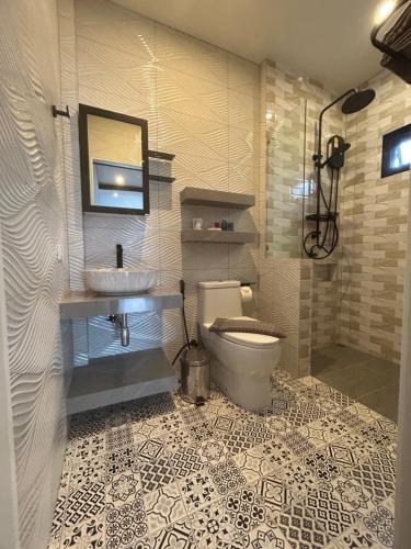 a bathroom with a toilet and a sink and a mirror at Baan Fran Sim Da in Bang Tao Beach