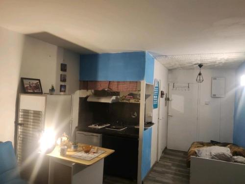 een kleine keuken met een fornuis en een koelkast bij studio proche plage in Saint-Georges-de-Didonne