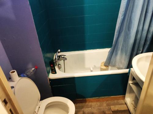 een badkamer met een bad, een toilet en een wastafel bij studio proche plage in Saint-Georges-de-Didonne