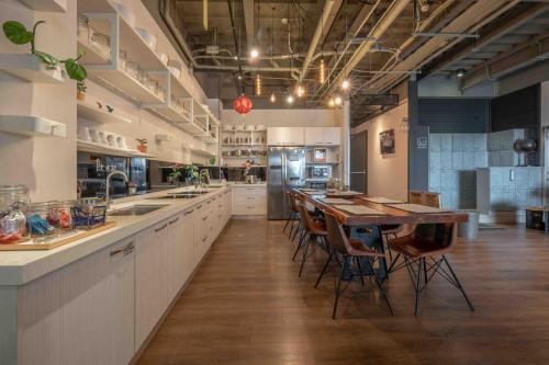 a large kitchen with a wooden table and chairs at Light Hostel Hualien in Hualien City