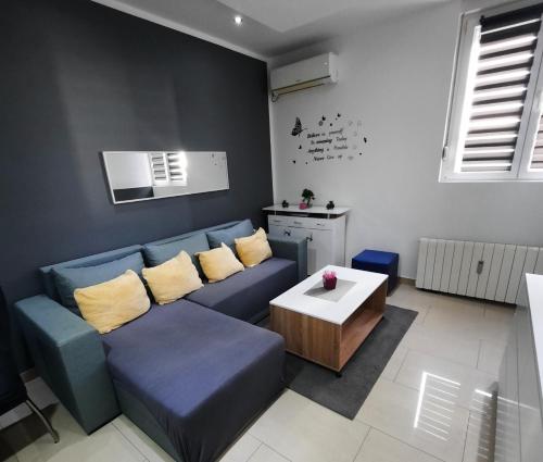 a living room with a blue couch and a table at Apartment Alex in Rijeka