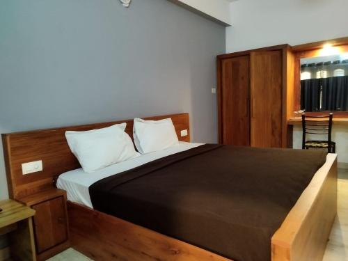 1 dormitorio con 1 cama grande y cabecero de madera en i-Jas Rock N View, en Meenangadi