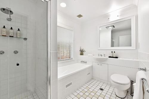 a white bathroom with a toilet and a shower at Villa 2br Nebbiolo Villa located within Cypress Lakes Resort in Pokolbin