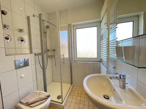 een badkamer met een wastafel, een douche en een toilet bij Fievfoten OG in Borkum