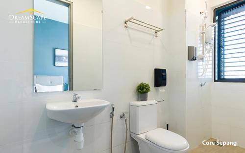 Baño blanco con aseo y lavamanos en Alanis & Core Soho Suite KLIA-KLIA2 By DreamScape, en Sepang