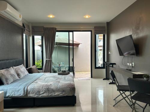a bedroom with a bed and a desk and a television at Baan Fran Sim Da in Bang Tao Beach