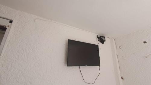 TV de pantalla plana colgada en la pared en Auto hotel el conquistador, 