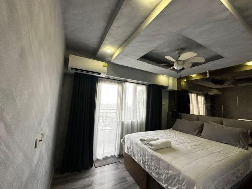 een slaapkamer met een bed en een plafondventilator bij Condo in Taguig, 2br condo, Acacia Estates, BGC, in Manilla
