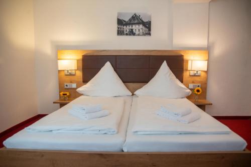 a bedroom with a bed with two white pillows at Hotel Restaurant Schwarzer Adler in Bad Saulgau