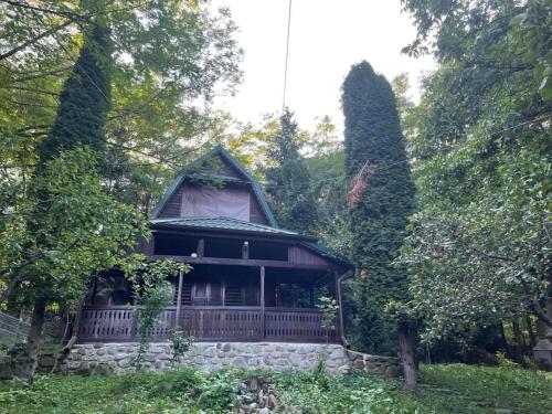 una casa antigua con una valla y árboles en Nest in the Nature, en Brebu Megieşesc