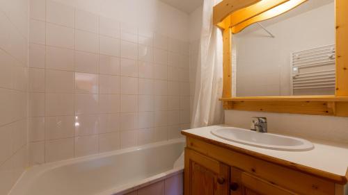 une salle de bain avec un lavabo et une baignoire dans l'établissement LES BICHES 78 - Appt lumineux 4-6 pers, à Saint-Sorlin-dʼArves