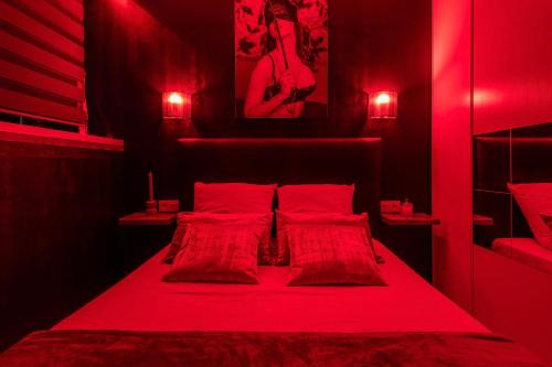 a red bedroom with a bed with red lights at Village Naturiste R4N - La Villa Beach&Club Luxe in Cap d'Agde