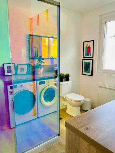 une salle de bains colorée avec un lave-linge et des toilettes. dans l'établissement Villa Dream Fort à La Baule, à La Baule