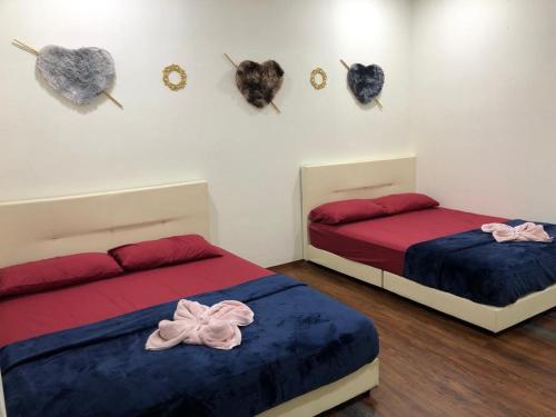 two beds in a room with hearts on the wall at CZ CLASSIC in Pasir Puteh