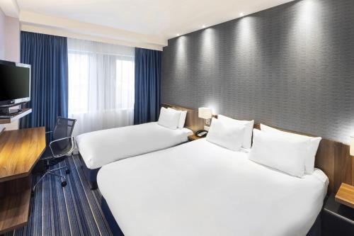 Cette chambre comprend 2 lits et une télévision. dans l'établissement Holiday Inn Express Amsterdam Arena Towers, an IHG Hotel, à Amsterdam