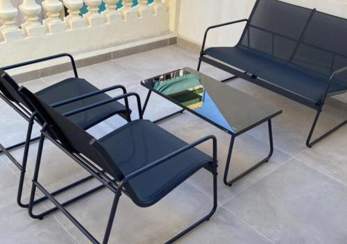 two black chairs and a glass table in a room at Apartamentos Loliqui centro Alicante in Alicante