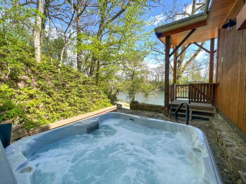 - un bain à remous dans l'arrière-cour d'une maison dans l'établissement Détente au Bord de l'Eau - Le Chalet du Carla avec Spa et Ponton Privé, à Castelnau-de-Lévis