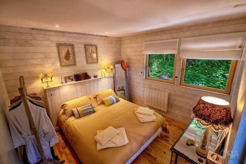 ein Schlafzimmer mit einem großen Bett in einem Zimmer in der Unterkunft Détente au Bord de l'Eau - Le Chalet du Carla avec Spa et Ponton Privé in Castelnau-de-Lévis