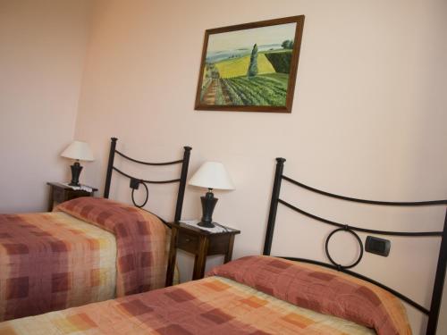a room with two beds and a picture on the wall at B&B La Gibiana in Costigliole dʼAsti