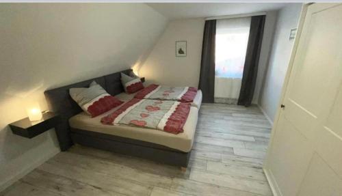 um quarto com uma cama e uma janela em Ferienwohnung mit WiFi und 2 Schlafzimmern em Ipsheim