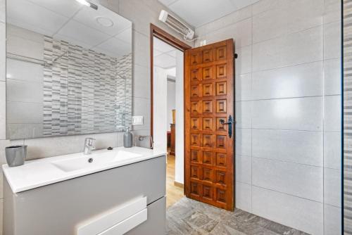 a bathroom with a sink and a wooden door at Albatros 2 in Denia