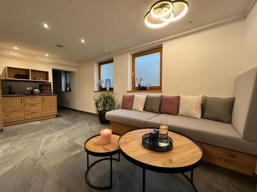 a living room with a couch and two tables at Pension Edelweiß in Sankt Johann im Pongau